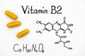 Chemical formula of Vitamin B2 and yellow pills. Royalty Free Stock Photo