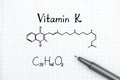 Chemical formula of Vitamin K with pen Royalty Free Stock Photo