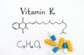 Chemical formula of Vitamin K and some pills. Royalty Free Stock Photo