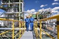 chemical industry plant - workers in work clothes in a refinery with pipes and machinery Royalty Free Stock Photo