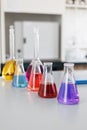 Chemical laboratory flask with blue purple-pink liquid stand on the table Royalty Free Stock Photo
