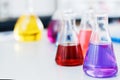 Chemical laboratory flask with blue purple-pink liquid stand on the table Royalty Free Stock Photo
