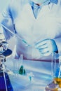 Chemical laboratory workers are doing tests with blue liquid in test tubes, biological experiments Royalty Free Stock Photo
