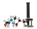 Chemical molecule model with old microscope over white background