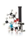 Chemical molecule model with old microscope over white background Royalty Free Stock Photo