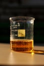 A chemical reaction to produce liquid bromine in a beaker, in the sunlight.