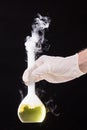 Chemical reaction in volumetric flask glass kept in the hands of Royalty Free Stock Photo