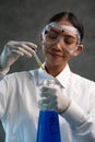 Young female chemist doing science experiment with chemicals Royalty Free Stock Photo