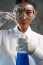 Young female chemist doing science experiment with chemicals Royalty Free Stock Photo