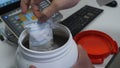 Chemical scientist opening white unlabeled plastic tank canister with chemicals on laboratory table Royalty Free Stock Photo