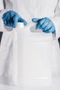 Chemical scientist opening white unlabeled plastic tank canister Royalty Free Stock Photo