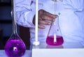 The chemist adds solutions with precision, ensuring accurate neutralization in the acid-base titration experiment