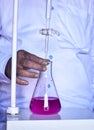 The chemist conducts acid-base titration, accurately measuring and adding solutions