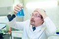 Chemist crazy. A mad scientist conducts experiments in a scientific laboratory. With surprised eyes, he examines the Royalty Free Stock Photo