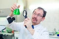 Chemist crazy. A mad scientist conducts experiments in a scientific laboratory. With surprised eyes, he looks through a Royalty Free Stock Photo