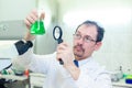 Chemist crazy. A mad scientist conducts experiments in a scientific laboratory. With surprised eyes, he looks through a Royalty Free Stock Photo