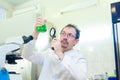 Chemist crazy. A mad scientist conducts experiments in a scientific laboratory. With surprised eyes, he looks through a Royalty Free Stock Photo