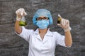 Chemist examining test tube with substance. She`s in protective uniform over grey abstract grey background Royalty Free Stock Photo