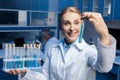 Chemist in lab coat holding tubes at laboratory