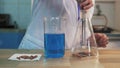 Chemist in laboratory holding test tube during the reaction - metal iron chemical test