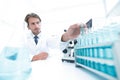 Chemist looking at test-tubes with blue liquids Royalty Free Stock Photo