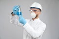 Chemist in mask holding flask.