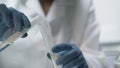 Chemist pouring boiling fuming liquid into test tube, conducting experiment