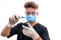 Chemist in protective uniform holding flask and test tube with minerals isolated on white. Science and experiment concept