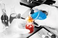 Chemist student boy pouring blue liquid in beger glass to erlenmeyer flask chemistry with red liquid on biochemical experiment. Royalty Free Stock Photo