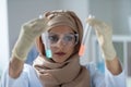 Chemist wearing stylish headscarf holding test tubes with chemicals Royalty Free Stock Photo