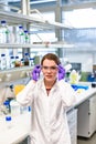 Chemist woman puts on plastic goggles in laboratory Royalty Free Stock Photo