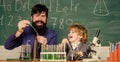 Chemistry beaker experiment. bearded man teacher with little boy. Laboratory test tubes and flasks with liquids father