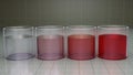 Chemistry beakers filled with colorful liquids. Pure clear water transitions to shades of red. 3d render illustration.