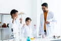 Young African boy in a white lab coat learns about an experimental error in blue textbook after a teacher teaches how to correct