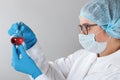 In a chemistry lab, a female pharmacist is analyzing a flask with red liquid. Medical experiment with a tube.