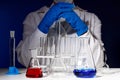 In a chemistry lab, a female pharmacist is sitting at a table surrounded by test tubes. Medical experiment.