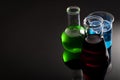 Chemistry laboratory and chemicals concept wit flask, test tube and other lab glassware containing green, red and blue color Royalty Free Stock Photo