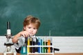 Chemistry. The Science Classroom. Lab microscope and testing tubes. Little children at school lesson. Blackboard for Royalty Free Stock Photo