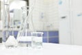 Chemistry Science laboratory flask, beaker and glassware with clear liquid chemical in blur background. Royalty Free Stock Photo