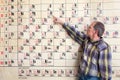 Chemistry teacher points at periodic table on wall