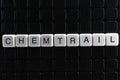 Chemtrail text word crossword. Alphabet letter blocks game texture background. Black background.