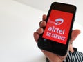 Selective focus of holding mobile and displayed Airtel 5G on a mobile device screening mobile