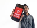 Chennai, India, August 2022 :Selective focus of a young boy holding mobile and displayed on Airtel 5G on a mobile device screen