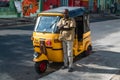 A taxi driver posing in front of his traditional yellow auto rickshaw in Chennai, India Royalty Free Stock Photo