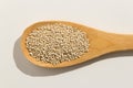 Golden Quinoa seed. Nutritious grains on a wooden spoon on white