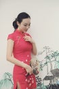 Asian Eastern oriental Chinese woman beauty in traditional ancient dress costume red cheongsam in ancient white wall with ink-wash Royalty Free Stock Photo