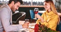 Cherful talking in restaurant. Couple holding red wine in glasses in restaurant