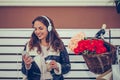 Cherful young woman listening music in headphones and using smartphone