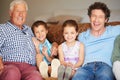 Cherished family moments. two children sitting with their father and grandfather indoors. Royalty Free Stock Photo