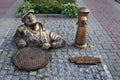 Cherkasy, Ukraine - August 14, 2021: A metal statue of a plumber looking out of a manhole near the central office of Cherkasy